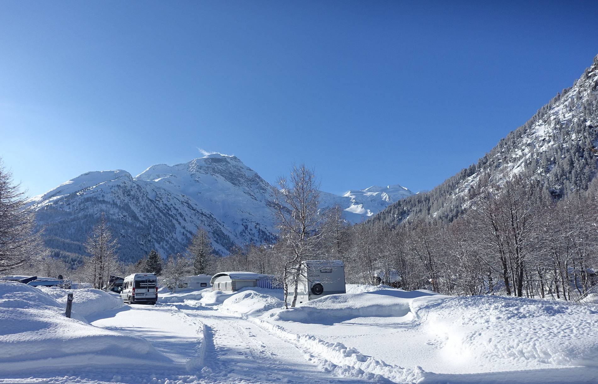 Wohnmobil und Kastenwagen auf dem frisch verschneitem Camping Morteratsch